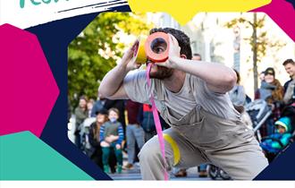 A social card promoting Basingstoke Festival. The main image is a person dressed in cream dungarees holding colourful duct tape to create the look of