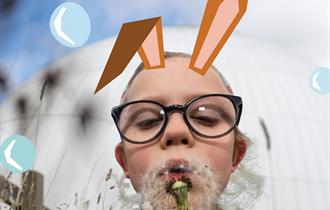 A little girl with illustrated bunny ears blows a dandelion