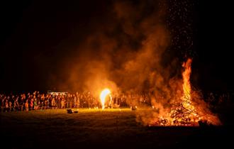 Fire Performer in front of a bonfire