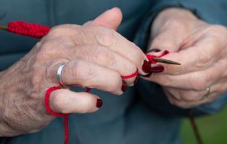 A close up of a lady knitting