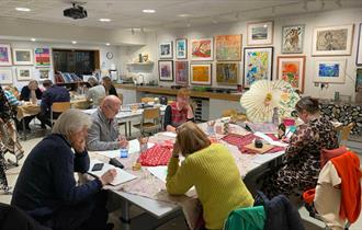 A group of people drawing in the studio during a drink and draw workshop