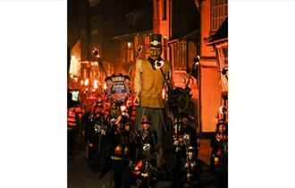Image shows the parade at Hastings Bonfire. The parade is full of bonfire society members with an effigy.