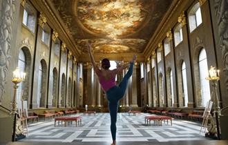 Woman doing a yoga pose in the Painted Hall.