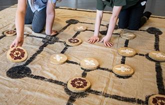 A Tudor board game laid out in cloth with large wooden counters