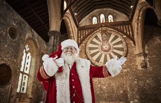 Father Christmas with The Great Hall and Round Table in the background.