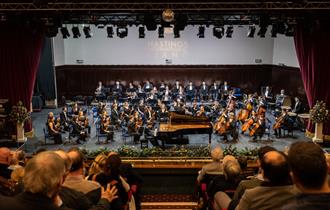 orchestra on stage with conductor