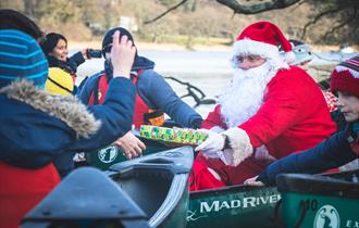 Santa giving a child a present in a canoe