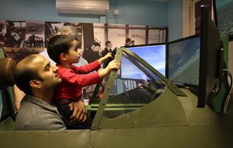 Maidenhead Heritage Centre: man and boy enjoying the Spitfire Simulator