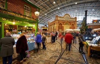 People walking around a museum at a Christmas market