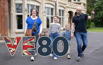 A family of a mum, dad, daughter and son outside Bletchley Park Mansion
