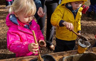 Children playing in an outdoor mud kitchen
