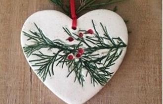 Heart shaped ceramic with pressed pine and berries shapes