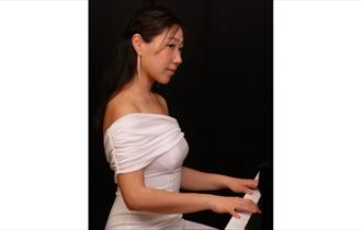 Nurry Lee in a White Dress at the Piano