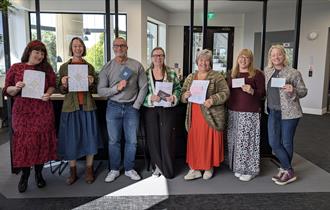 A group of people looking happy with their work on completion of a workshop