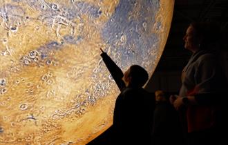 A child points at Mars