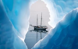 A yacht on the water through a hole in the ice