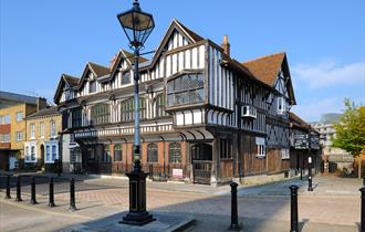 Picture of the front of Tudor House with blue sky in the background
