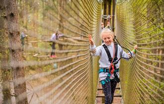 Girl on obstacle at Go Ape Alice Holt