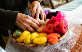 hands in multi-coloured wool