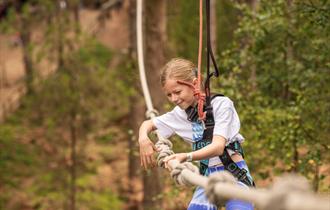 Girl on obstacle at Go Ape Bedgebury