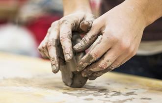 Child's hands playing with block of clay