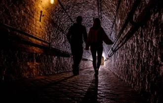 Couple taking tour of Dover Castle tunnels