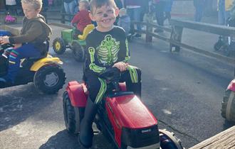 Child on Pedal Tractors during Halloween