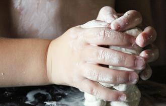 Child's hands playing with clay