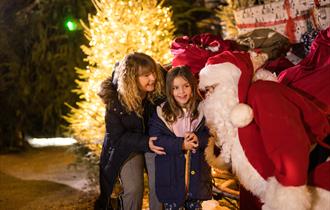 Little girl smiling with her grandmother and santa
