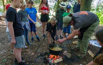 Children cooking around an open fire