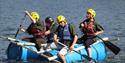 Team Activity Group - 4 adults on a raft made of barrels and wooden battens