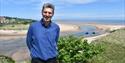 Photo of Dr Ben Robinson with the sea in the background, Isle of Wight Literary Festival, what's on, event