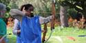 Team Activity Group - Lady in a blue vest doing archery