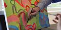 Team Activity Group - Gentleman's hand doing a vibrant painting.