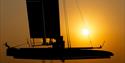 A foiling catamaran being transported at low light