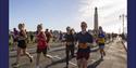 People taking part in the Great South Run, going past the War Memorial on Southsea Seafront