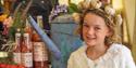 Girl with a garlic head band on standing next to local produce at the Isle of Wight Garlic Festival, what's on, event, Newchurch