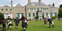 Children in historic dress running on lawn