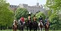 Royal Windsor Horse Show - variety of horse mounted performers in uniforms/national dress with Windsor Castle in background
