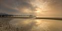 Sunset through the clouds with Sandown Pier in the distance, Sandown beach, Isle of Wight, Things to Do