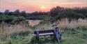 Sun setting at Dorney Wetlands, Berkshire with bench and bike credit Becca_zimbali