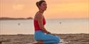 Lady sitting on yoga mat on the beach, Joyride Festival, Isle of Wight, cycling, wellness, health & wellbeing, food, music, what's on, event