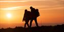 Couple walking on cliff at sunset, Isle of Wight, what's on