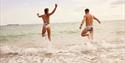 Two people running in to the sea, Joyride Festival, Isle of Wight, cycling, wellness, health & wellbeing, food, music, what's on, event