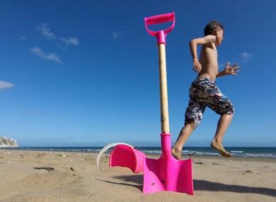 Boy next to bucket and spade on Yaverland Beach, Sandown, Isle of Wight, Things to Do
