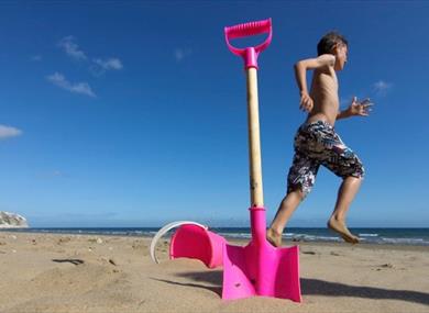 Boy next to bucket and spade on Yaverland Beach, Sandown, Isle of Wight, Things to Do