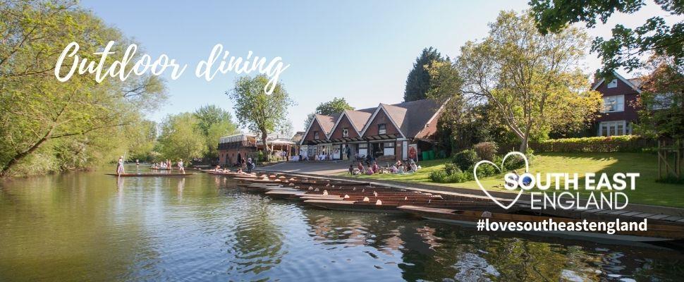 View of Cherwell Boathouse from the River with outdoor dining space and punts for hire