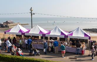 Group of purple and white covered stalls on Broadstairs seafront selling food and drink