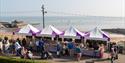 Group of purple and white covered stalls on Broadstairs seafront selling food and drink