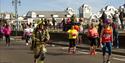 Runners nearing the Great South Run finish line, including a man in a firefighter's outfit